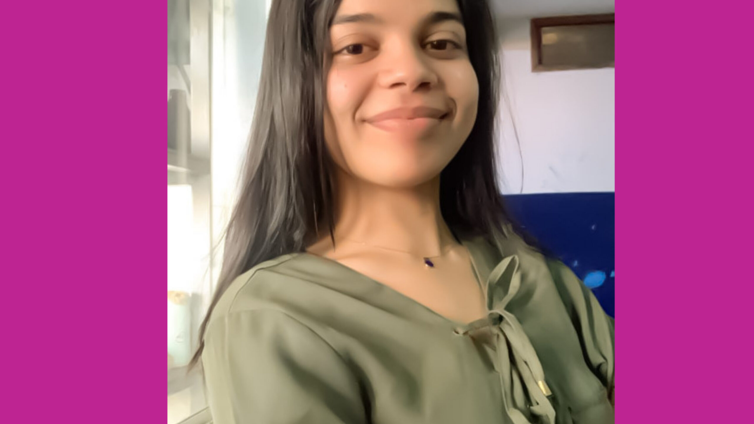 Image of a confident woman standing in a corporate setting, possibly delivering a presentation.