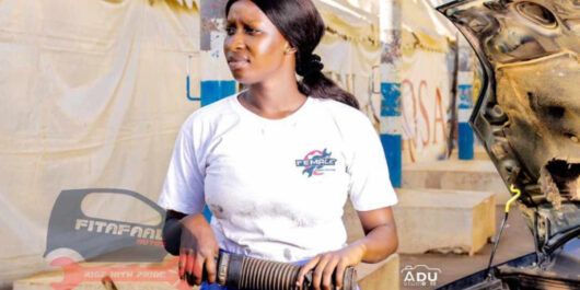 Image of Ida Faal, a female auto mechanic, working on a car in The Gambia.