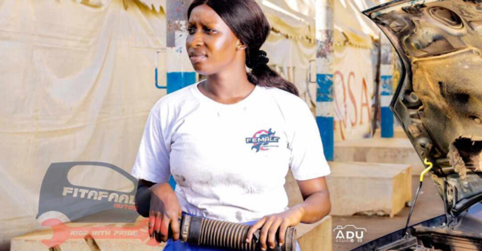 Image of Ida Faal, a female auto mechanic, working on a car in The Gambia.